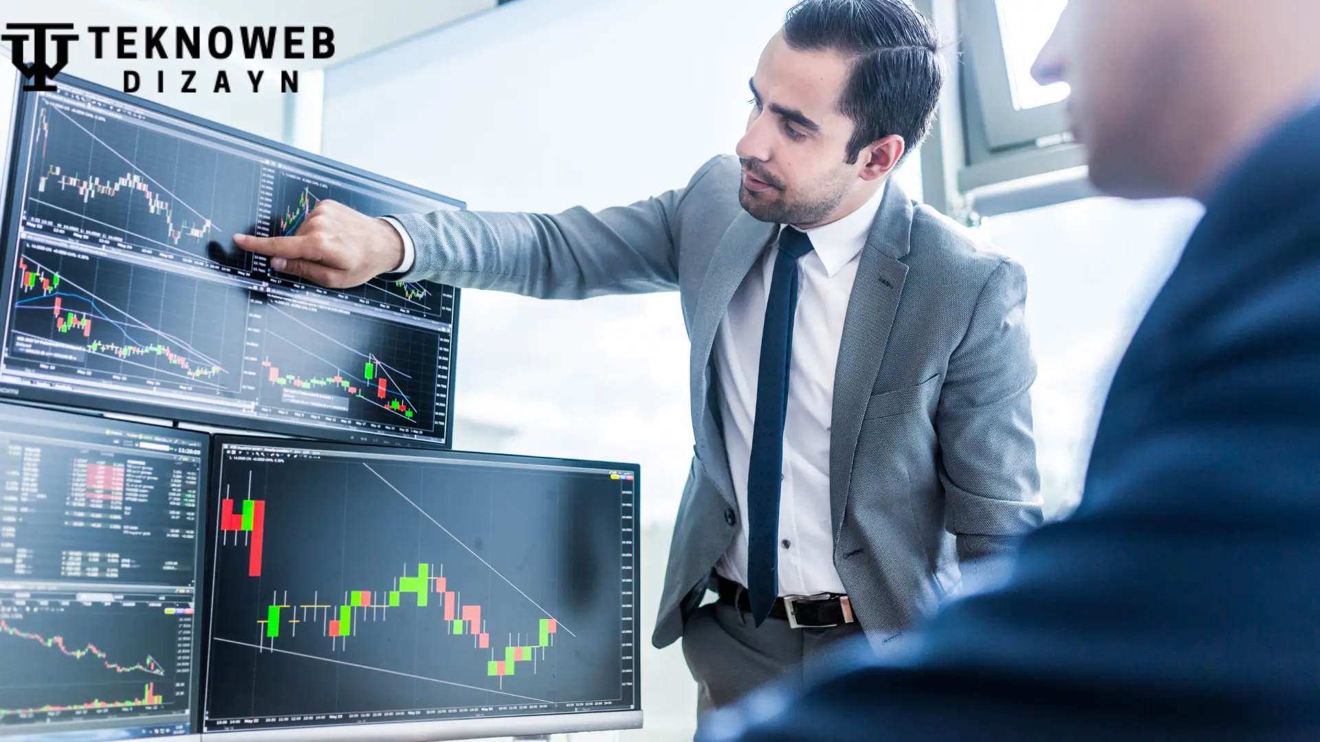 Spartan Capital Securities LLC broker Jordan Meadow analyzing stock market trends on multiple monitors in an office setting.