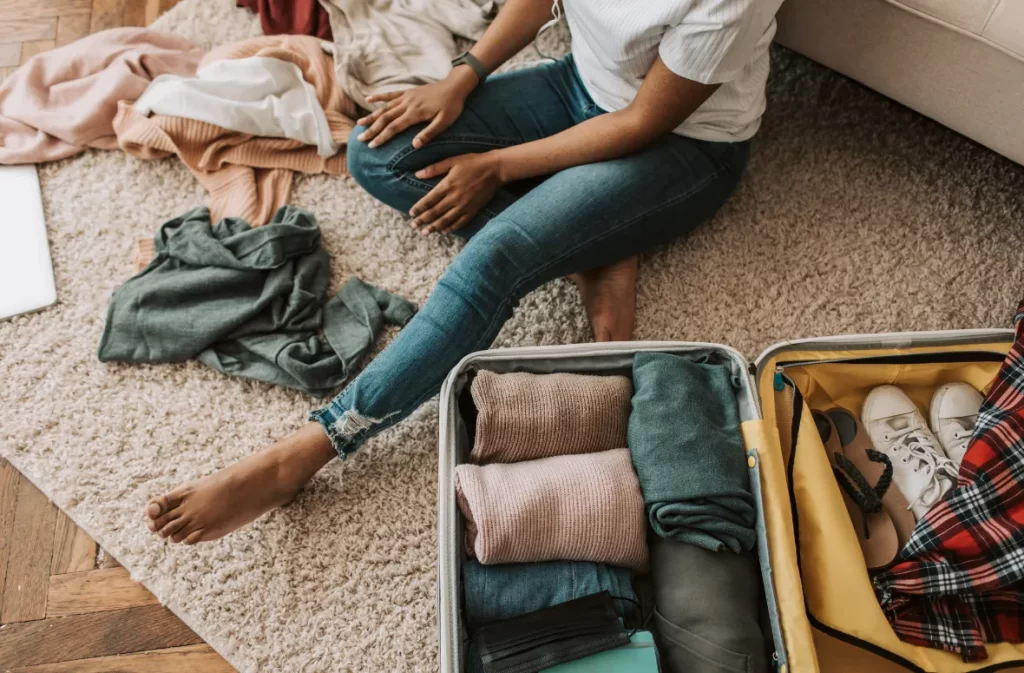 A traveler sorting clothes and organizing a suitcase – what is day packing and how to pack efficiently?