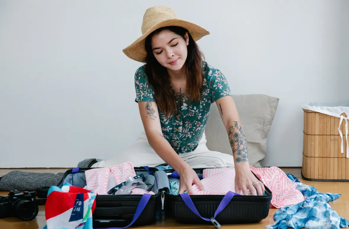 A woman packing summer essentials in a suitcase – what is day packing for a light and organized trip?