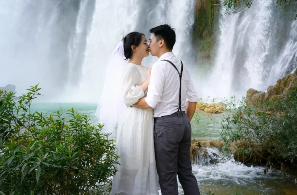 A breathtaking waterfall elopement with a couple sharing a kiss, celebrating love in a stunning natural setting.